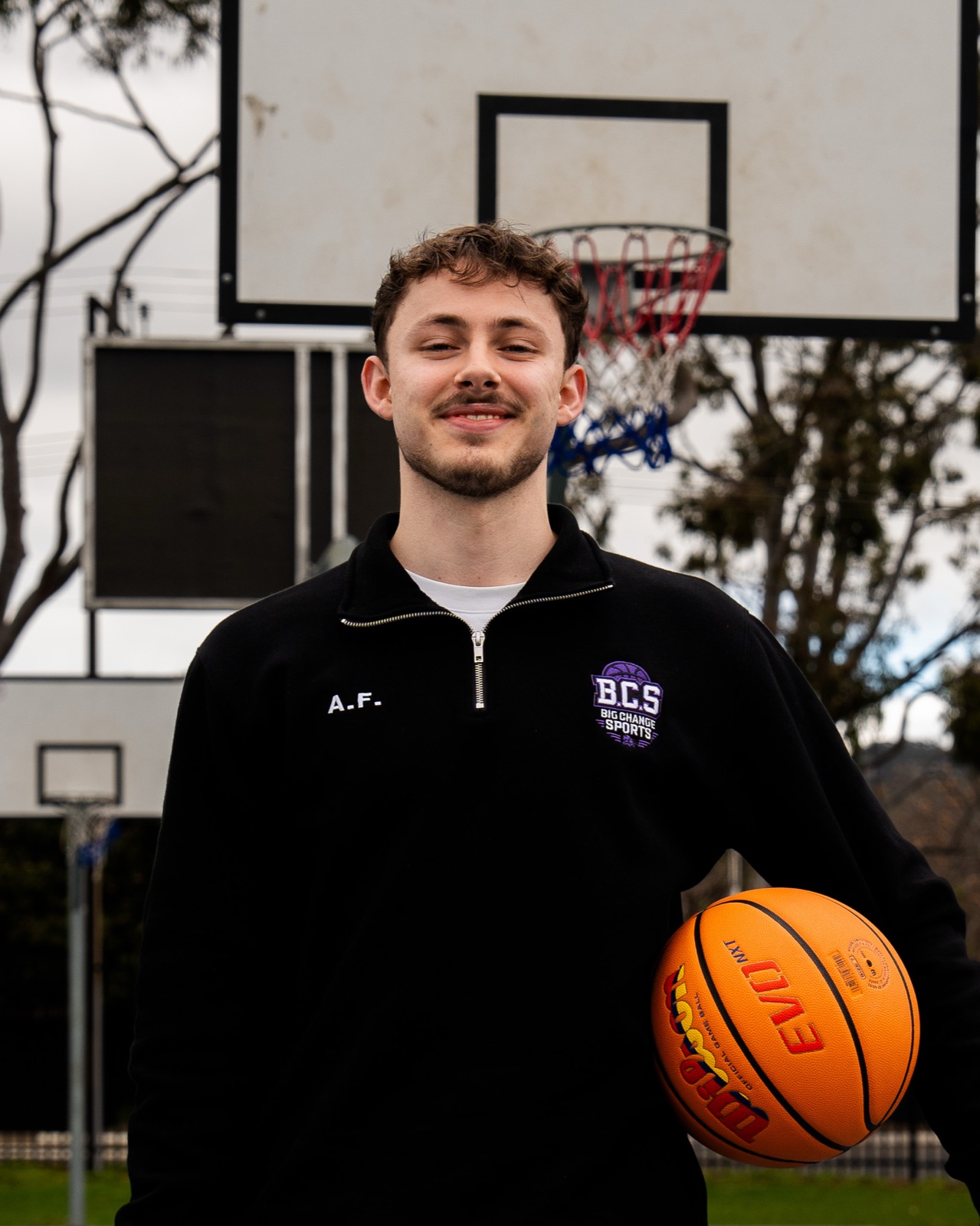 Armand Fouche holding a basketball on an outdoor court