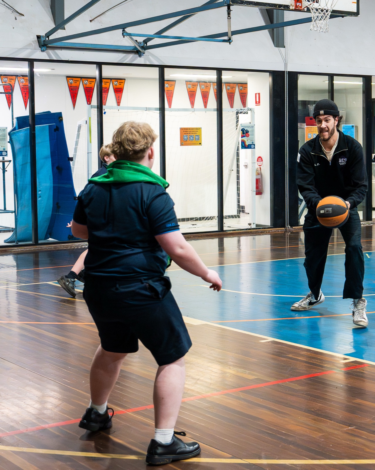 Coach passing a basketball to a student