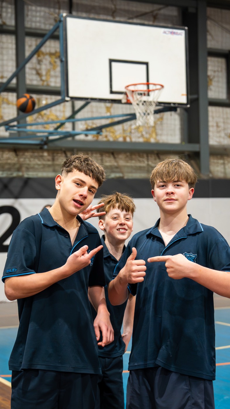 Three students giving a thumbs up on court